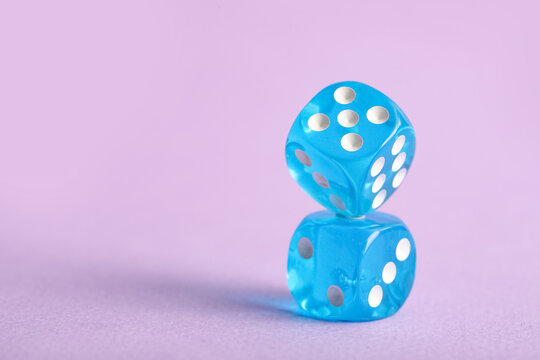 Blue game dices on lilac background