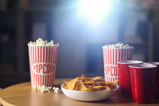 Tasty snacks prepared for watching of movie on table in evening