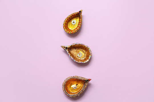 Diya lamps on purple background. Divaly celebration