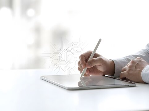 Person using stylus on tablet with glowing circuit interface