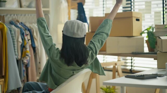 Starting SME Small business entrepreneur,Online business, Work at home concept.Asian business woman using a laptop computer and phone call receive checking customer order online shipping boxes at home