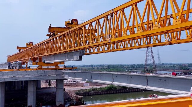 This is the yellow steel structure of a launcher gantry that will be used for erection precast concrete I Girder across the river, 