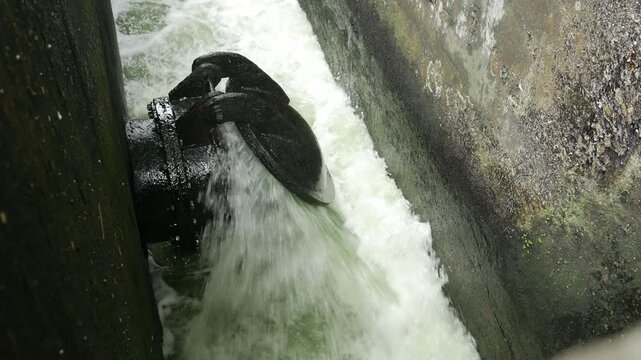 Iron Sluice Valve with Powerful Green Water Splash Close-Up