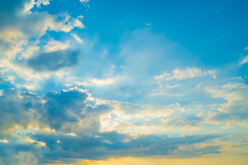 Obraz premium A bright sky at sunrise. A background of clouds in the blue sky with an orange section below.