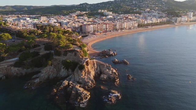 Aerial view taken from a drone of the coast of Lloret de Mar, Costa Brava, Spain, early in the morning at sunrise - the sea, beach and coastal hotels