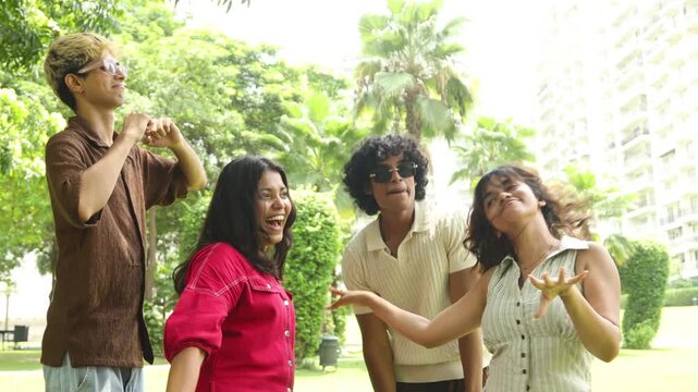 Diverse indian asian Gen z young adult friends dancing hand having fun together outdoor. sharing a happy carefree moment and representing youth and friendship in a summer park. enjoy life.