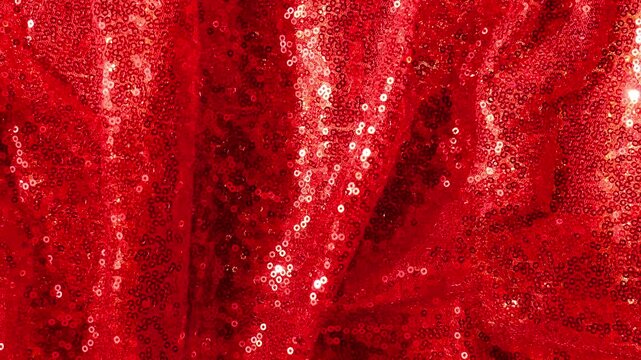red sequin shiny fabric.red sequin fabric with glowing highlights. fashion fabric.Christmas, New Years holiday banner
