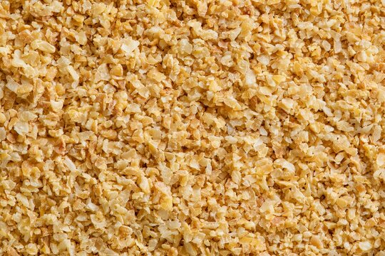 Ground grains are spread on a surface for processing and packaging in a local food market