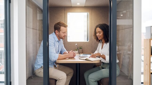 Colleagues planning in private meeting booth