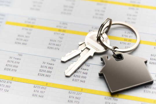 House keys with home charm on financial spreadsheet