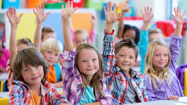 Diverse elementary school children eagerly raising hands during a bright classroom lesson for educational concepts