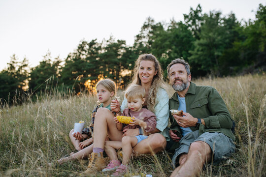 Family hiking together through countryside during summer camping trip.