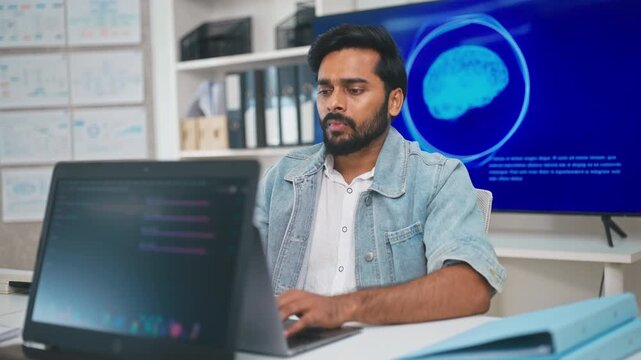 Indian man working with artificial intelligence on laptop in office, interacting with virtual assistant app for productivity, AI-powered speech, and smart technology.