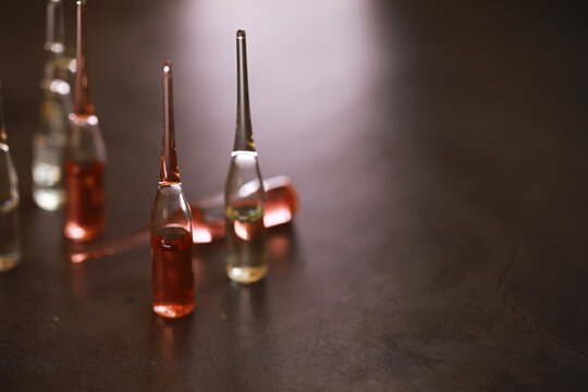 Colorful Glass Vials on Dark Surface: Aesthetic Display of Liquid Science and Medicine