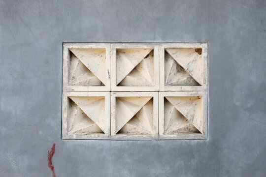 Gray concrete wall background with geometric patterned box roster ventilation