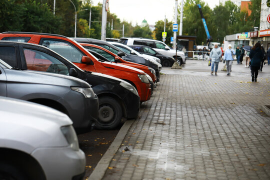 Urban Parking Scene with Various Cars Lined Along City Street in Overcast Weather