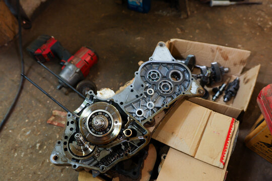 Gearbox housing gear mechanism tool repair workshop automotive exposed metal gearbox housing exposed gear mechanism with tool repair workshop, open transmission part floor beside cardboard box