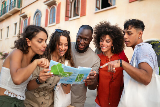 Friends enjoy a summer afternoon exploring the city, laughing over a map and discovering the city
