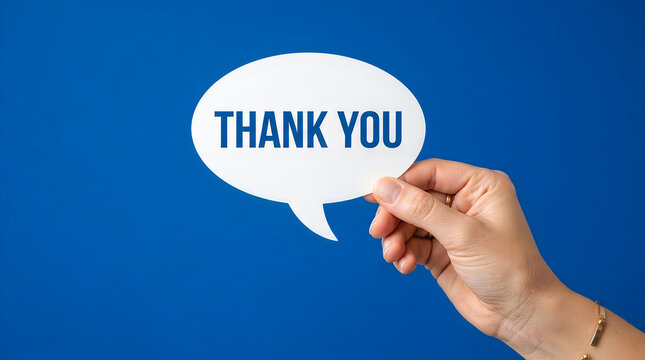 Hand holding white paper speech bubble sign with thank you text against solid vibrant blue background