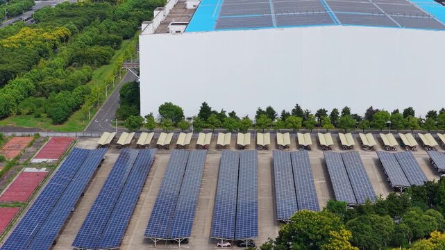 Aerial view of solar carports and a building with rooftop panels