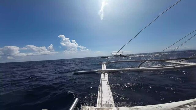 Outrigger boat sailing across the tropical ocean