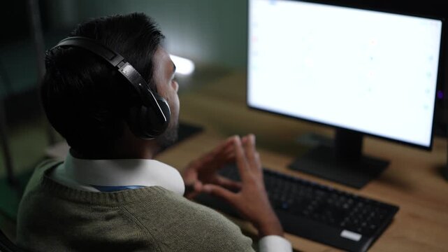 A thoughtful engineer at a transparent board runs a hand along his jaw before reaching up to move one card in the workflow inside a dimly lit machine learning startup office.