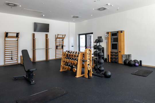 Luxury hotel gym interior with wooden wall bars and fitness equipment