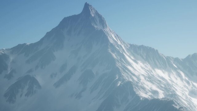 A tall mountain stands against a clear sky. Snow covers its peak and slopes. Light shines brightly, highlighting the rocky texture and snowy patches. This scene shows a natural landscape.