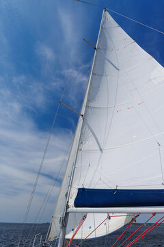 White sail against blue sky on sailing yacht