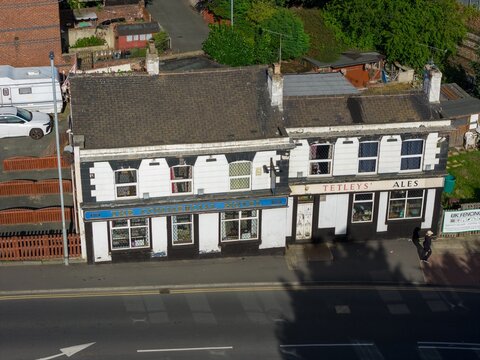 Castleford, Yorkshire UK, 5th September 2026: Aerial view of The Commercial Hotel and Tetley's Ales frontage beside a road with neighbouring homes and railway in Castleford