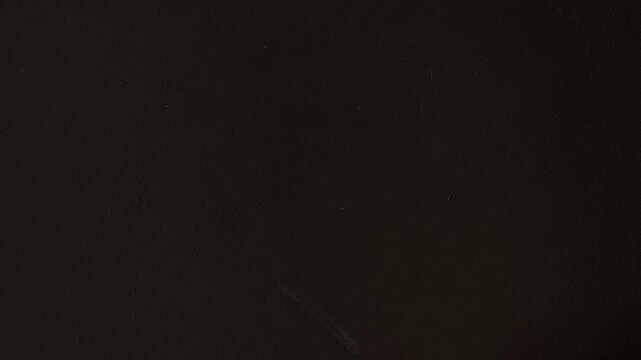 Woman sticking a yellow note with the word &ldquo;School&rdquo; on a black wall, symbolizing the beginning of the school year, education, learning and Back to School concept.