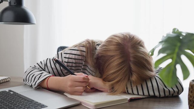 Tired overworked student napping on her desk while writing in a notebook, then waking up and showing a thumbs up, a symbol of resilience and perseverance
