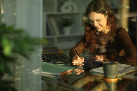Happy telecommuter handwriting on tablet working at home