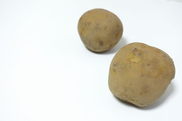 Fototapeta premium Horizontal arrangement of two potatoes on a white, food photo