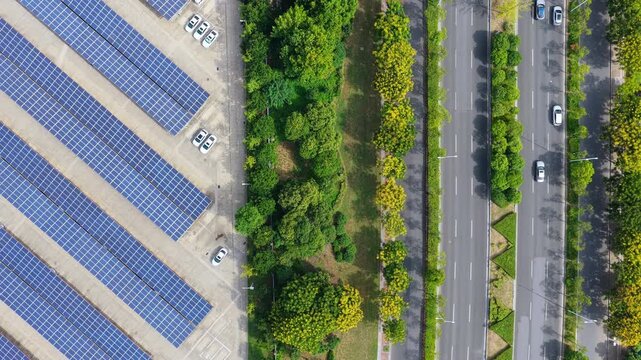 Top down tracking view of solar parking beside road traffic
