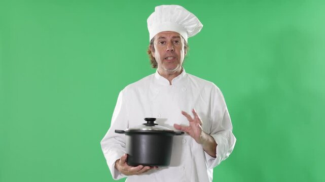 Qualified chef holds a saucepan in his hands against the background of chromakey. Male chef invites you to a master class on cooking soups . High quality 4k footage