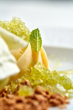 Gourmet ice cream dessert with refreshing lemon granita, meringue and crumble on white plate. High-end restaurant plating isolated on white background.