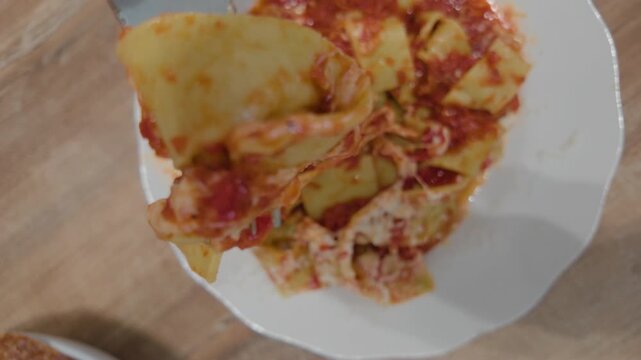 Overhead view of pappardelle pasta in tomato sauce with a fork lifting a bite