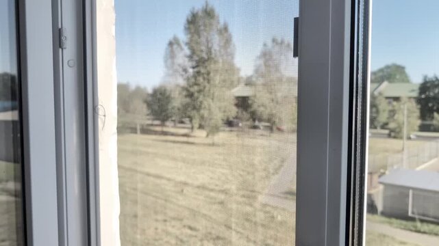 Male hand turns white PVC window door handle opens for ventilation home. Close window
