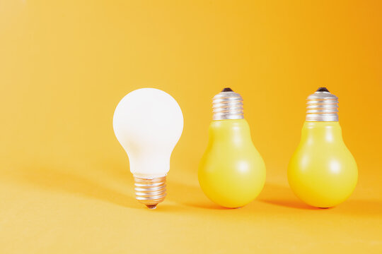Light bulb and incandescent lamp on a yellow background. Creative idea concept.