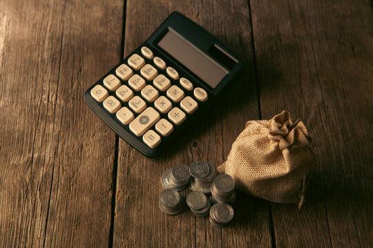calculator and money bag on wooden table, business and finance concept