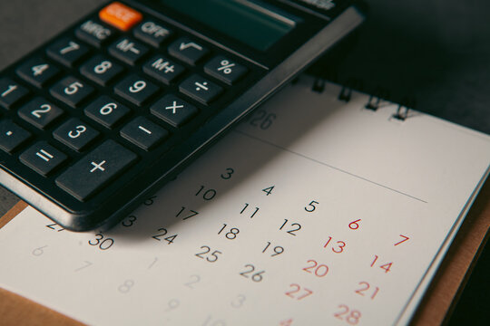 Calendar with calculator on black table, business and finance concept.