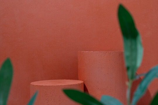 Product Presentation Scene made with Terracotta Cylinder Podium with Tropical Green Plant Leaves on Pink Terracotta Background