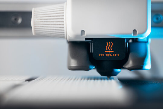Extreme macro shot of 3D printer nozzle printing white plastic object