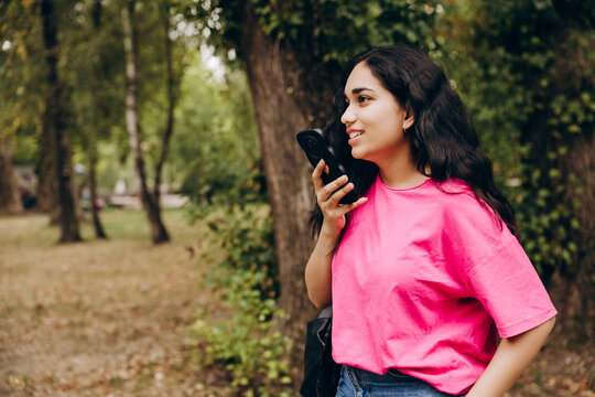 Woman sending voice message on phone in park