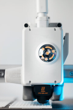 Close up of 3D printer nozzle with caution hot warning sign