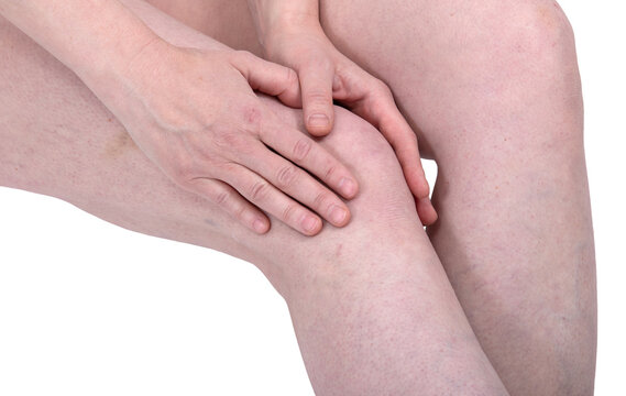 Woman touching her painful knee. Medical concept of joint inflammation and chronic arthritis pain. Relief massage for knee injury or osteoarthritis. Healthcare treatment for leg discomfort
