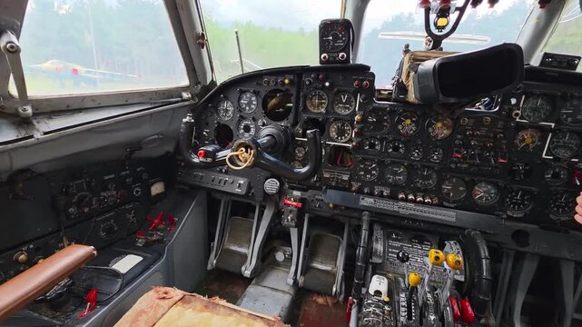 Interior view old airplane cockpit showing intricate dashboard many gauges, dials, levers, steering yoke, control pedals, vintage aircraft standing outdoors exhibition.