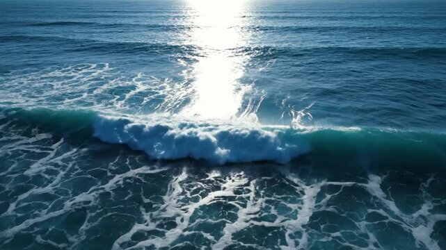 Aerial drone view of ocean waves rolling with sunlight reflecting on water surface