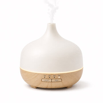 Modern diffuser releasing mist in white setting